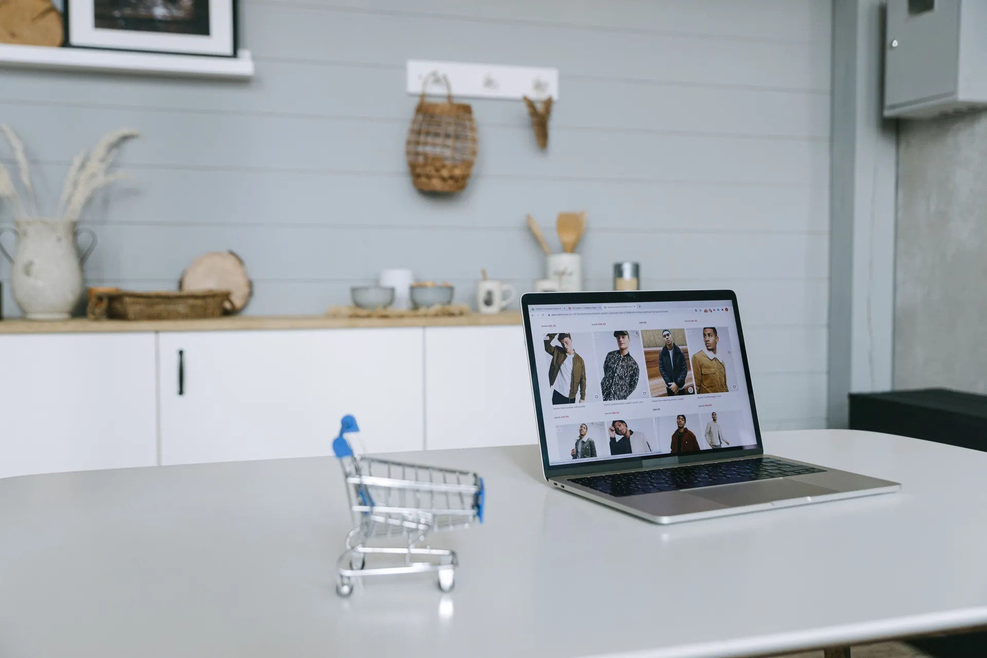 Notebook com uma vitrine online aberta em uma cozinha clara